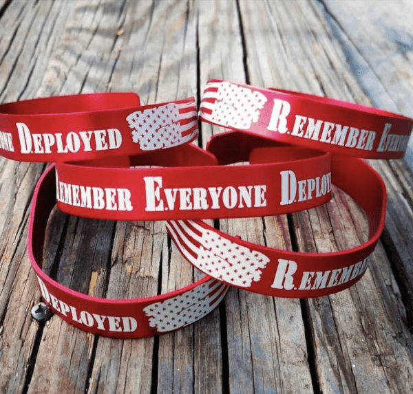 red memorial bracelet that says "remember everyone deployed"